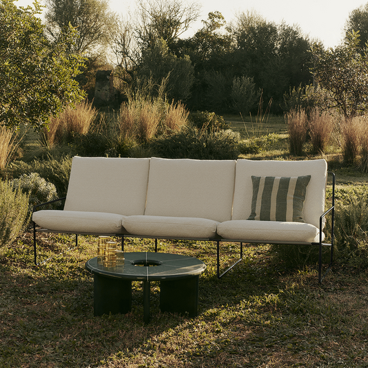 Utesofa Desert i Pure Bouclé / off-white med svart understell fra Ferm Living er designet for utendørs bruk med puter som er både vann- og UV-beskyttet.