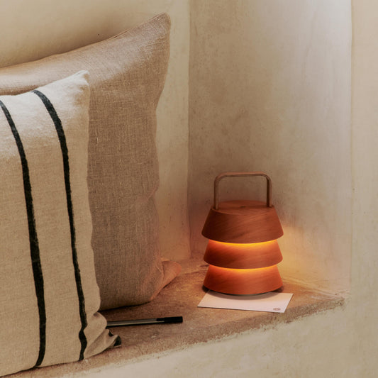 En nett og elegant lampe fra kolleksjonen Ferm Living x Utzon - Can Li. Den oppladbare lampen Luver Portable Lamp har en skulpturell form med stablede treskjermer i douglasgran og sprer et varmt, behagelig lys som skaper en lun atmosfære hvor enn du tar den med.