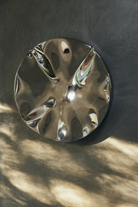 Veggskulpturen Dent Wall Sculpture fra HKliving skaper med sin forkrommede overflate en spennende refleksjon av lys og omgivelser. Superfin hengende alene eller sammen med andre dekorative malerier og objekter på en vegg.