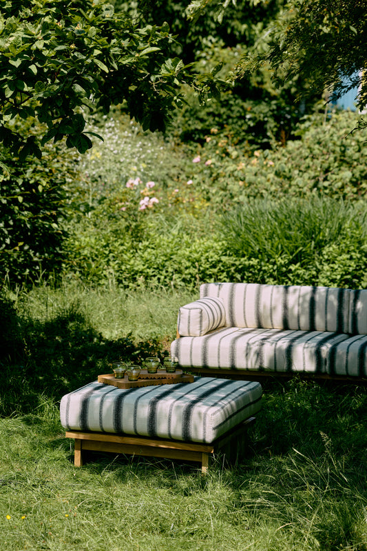 Denne puffen i teak fra HK Living passer perfekt til resten av serien Outdoor Teak, som består av en deilig dagseng og sofa til uteplassen! Puffen Outdoor Hocker Teak kan også gjerne brukes som et bord – og er like mye en ekstra sitteplass som et sted å hvile bena. Rammen er laget i værbestandig teak og du kan velge mellom fire fine tekstiler.