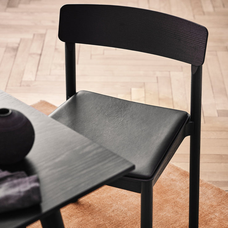 Stolen kan også leveres med sete trukket i skinn. Her er stolen i svartlakkert ask med svart skinn, Noble Black Leather.