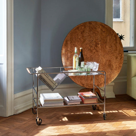 Trallen Alima fra &tradition er et superfint, fleksibelt møbel som du kan bruke til å oppbevare magasiner, bøker og annen inspirasjon – eller som en klassisk bartralle. Hjulene gjør den enkel å flytte rundt, og den kan dermed være med deg fra rom til rom, avhengig av hva du trenger den til, dag for dag.