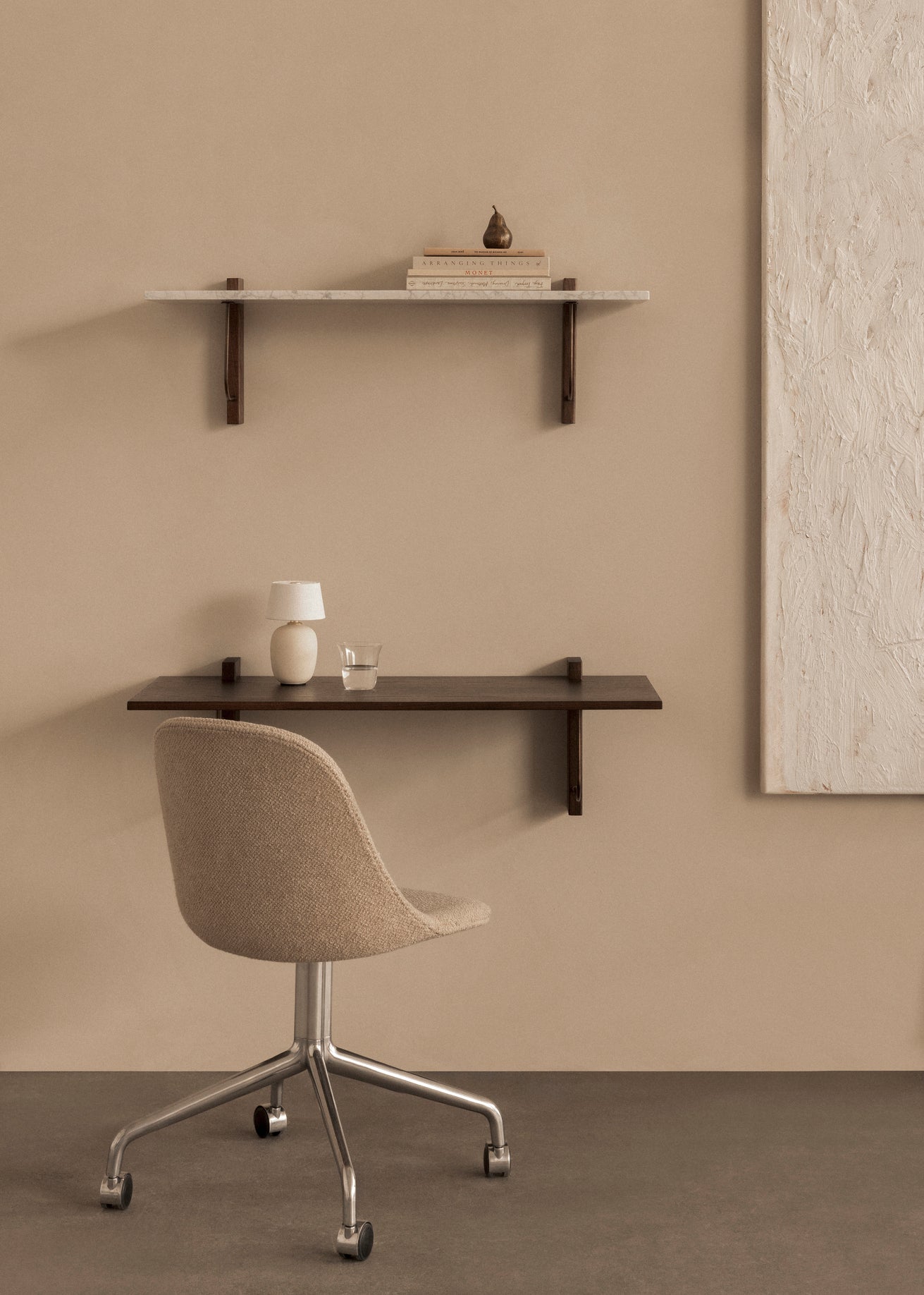 Hyllen Corbel Shelf Long fra Audo Copenhagen med hylleplate i hvit marmor og hylleknekter i mørk eik og det vegghengte skrivebordet Corbel Wall Desk i mørk eik.