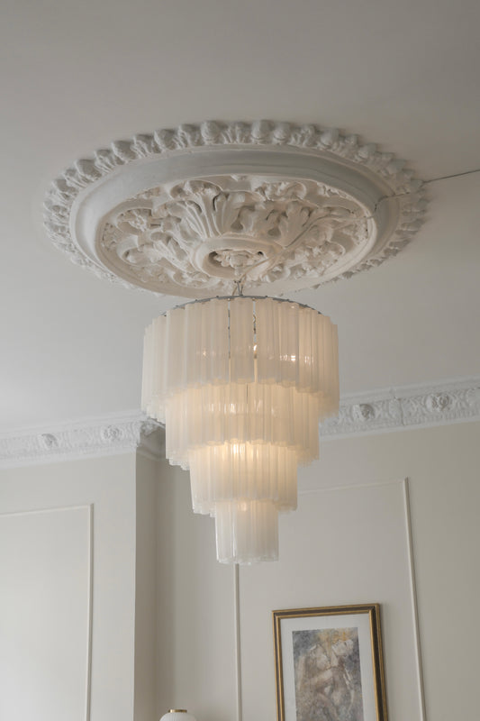 Her ser du lysekronen Fontaine Chandelier 4-layer fra Meublé i hvitt glass og krombelagt oppheng. Den stemningsfulle lysekronen er en del av en serie med lysekroner der du kan velge mellom tre ulike størrelser, der dette er den som bygger mest i høyden. Lysekronen måler Ø65 x H77 cm.