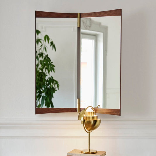 Speilet Vanity Mirror designet av GamFratesi for Gubi gir interiøret en elegant dose art deco-estetikk! Speilet i valnøtt og messing kommer i tre ulike størrelser og er superfine å bruke i alle rom! Designet er inspirert av klassiske boudoir-speil der betrakteren skal kunne beundre seg selv fra flere perspektiver.