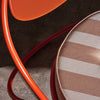 Utemøbelet Copacabana Outdoor Lounge Chair fra Gubi med oransje ramme og pute i tekstilet Leslie Stripe 040 med hvite og svakt oransje striper. Lenestolen er lett i vekt, noe som gjør den lett å flytte rundt. 
