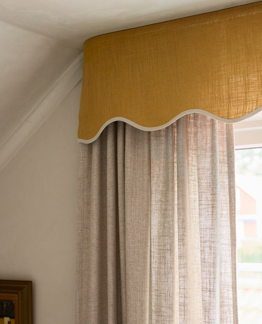 Gi gardinene dine en superelegant innramming med en skreddersydd vakker takmontert gardinkappe i vevd lin. Denne varianten med bølgekant – kalt Scallop Valance fra Gotain – er perfekt for deg som ønsker deg en hakket mer dekorativ gardinkappe til å dekke for gardinene hjemme på en iøyenfallende måte.