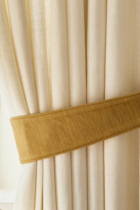 Gi gardinene dine et løft med en gardinholder i vevd lin fra Gotain. Bruk den når du vil slippe inn mer lys, eller samle gardinene pent til siden for et drapert og ryddig uttrykk. Gardinholderen finnes i ti ulike farger.