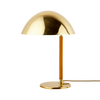Bordlampen 9209 fra Gubi har en myk silhuett og en fint perforert, mønstret skjerm i messing. Lampefoten som er kledd i spunnet rotting gir designet en egen taktilitet og varme. 