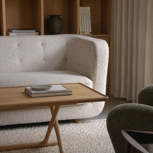 Sofaen Vilhelm fra Audo Copenhagen er en vakker 3-seters sofa designet av Flemming Lassen i 1935 som kombinerer slankhet med overdådighet. Navngitt etter designerens far og gjeninnført i 2019 som en del av Audo sin kolleksjon Audo Icons,  inviterer den til avslapning og ro. 