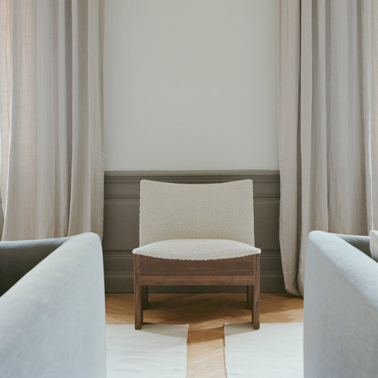 Tenon er designet av den spanske københavnbaserte designeren Omayra Maymó. Velg mellom naturfarget eller røkt heltre eik og to fine tekstiler. Her ser du loungestolen Tenon fra New Works i røkt eik (Fumed Oak) med lys bouclé i tekstilet Drake.