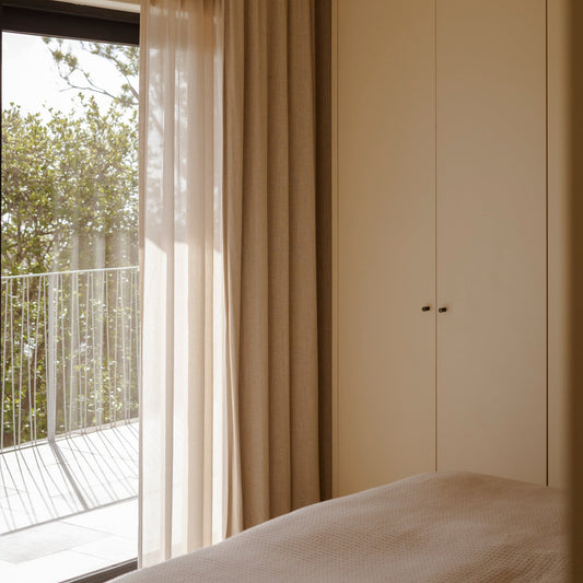 Mørkleggende vevd lingardin i fargen sand, sammen med florlett gardin.