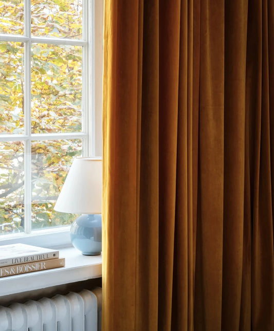 Vi elsker hvordan gardiner enkelt løfter innredningen til nye høyder og får ethvert rom til å kjennes lunere og hyggeligere på 1-2-3! Og den elegante velurgardinen fra Gotain rammer inn vinduet på ekstra vakkert vis. Tekstilet er en nydelig matt fløyelsvelur med tung drapering som sikrer et pent fall. Her i en fantastisk sennepsgul variant.