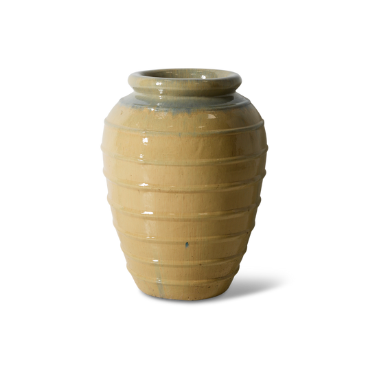 Gulvvasen er laget av keramikk av høy kvalitet og har en raffinert silhuett, med en teksturert glasert overflate. Merk at den ikke bør brukes innendørs om du skal ha jord / planter i.