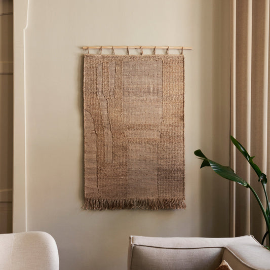 Veggteppet Harvest Wall Rug fra Ferm Living henger fra en rundstokk i bøk som gjør det enkelt å montere på veggen. Veggteppet kommer i to ulike størrelser.