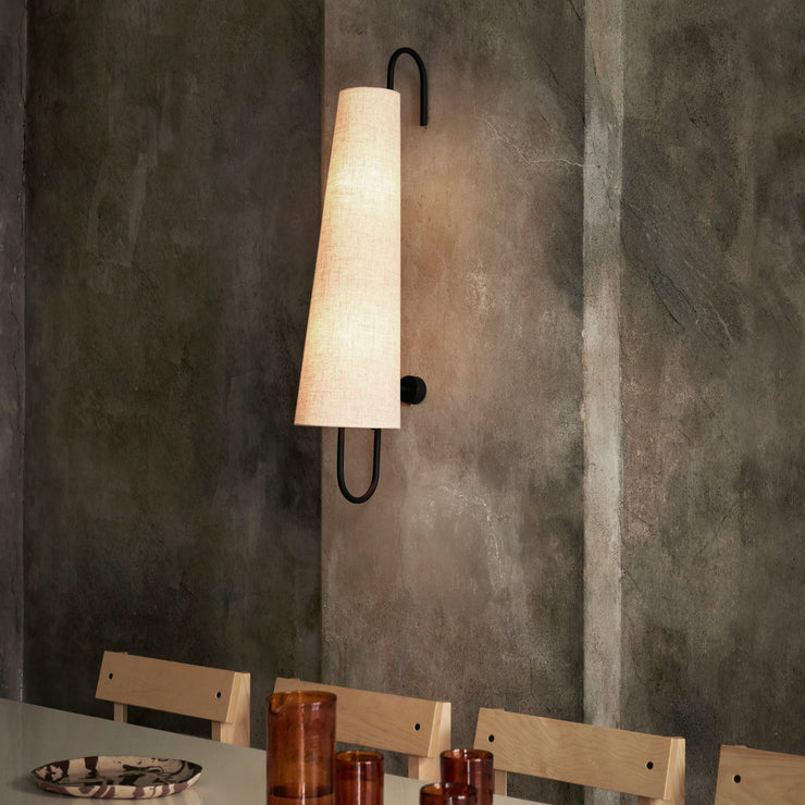 Vegglampen Ancora fra Ferm Living balanserer letthet og materialitet og skaper en behagelig atmosfære i alle rom.