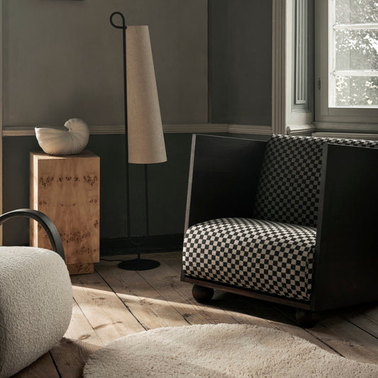 Ute etter et statementmøbel til stua? Lenestolen Rum Lounge Chair fra Ferm Living i det rutete tekstilet Check kan være nettopp det du ser etter. Dette er et klassisk mønstret, svart- og sandfarget tekstil som vi synes passer nydelig til den rause rammen i mørkbeiset furu.