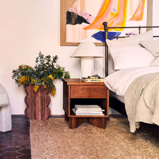 V Bedside Table fra Dusty Deco kommer i to ulike tresorter, begge i matt finish. Vi liker godt hvordan det er stylet sammen med andre naturmaterialer og lyse detaljer (her i varianten i bøk).