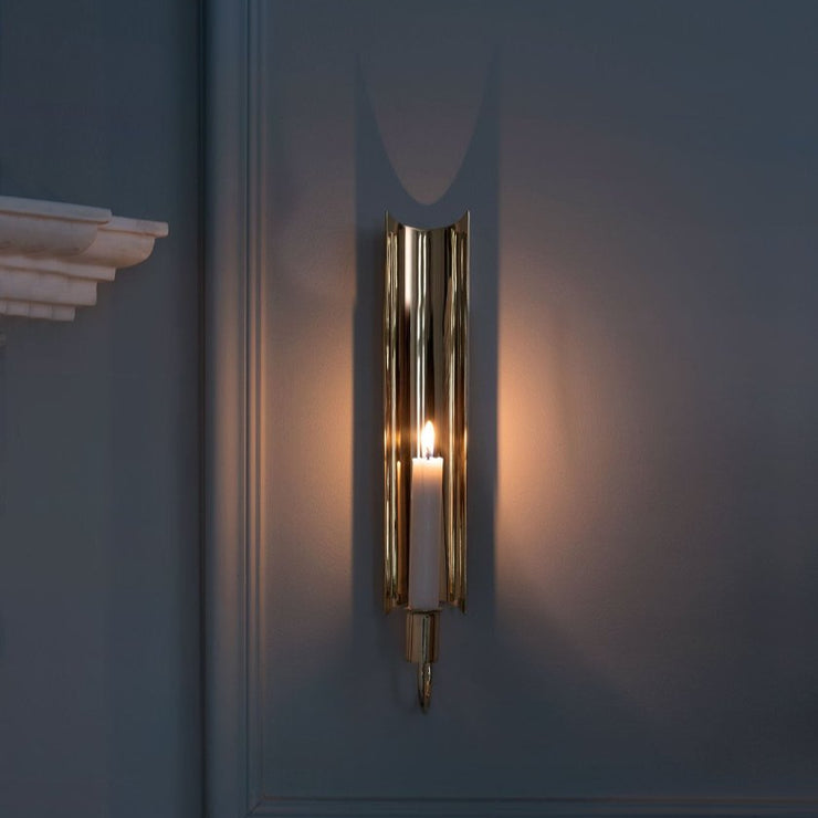 Vegglysestaken Reflex Sconce ble designet av sølvsmeden og designeren Pierre Forssell (1925-2004) for Skultuna på slutten av 60-tallet. Vi elsker de lange, elegante linjene i designet og hvordan stearinlyset reflekteres vakkert i den polerte overflaten. I tillegg til å være høyst dekorativ på veggen, gir den oss også en herlig nostalgisk følelse og en lyst til å ha kun dette som belysning i enkelte rom – slik man gjorde det før i tiden! 