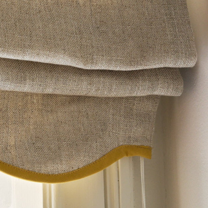 Sandfarget mørkleggende liftgardin i vevd lin Scallop Edge fra Gotain i fargen Sand / Mustard.