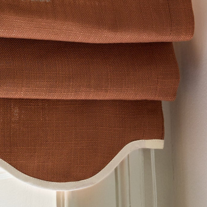 Terrakottafarget mørkleggende liftgardin i vevd lin Scallop Edge fra Gotain i fargen Terracotta / Ivory.