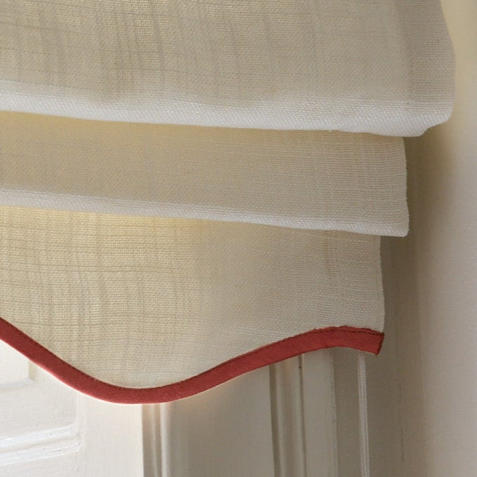 Benhvit mørkleggende liftgardin i vevd lin Scallop Edge fra Gotain i fargen Ivory / Terracotta.