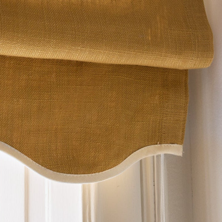 Sennepsgul mørkleggende liftgardin i vevd lin Scallop Edge fra Gotain i fargen Mustard / Ivory.