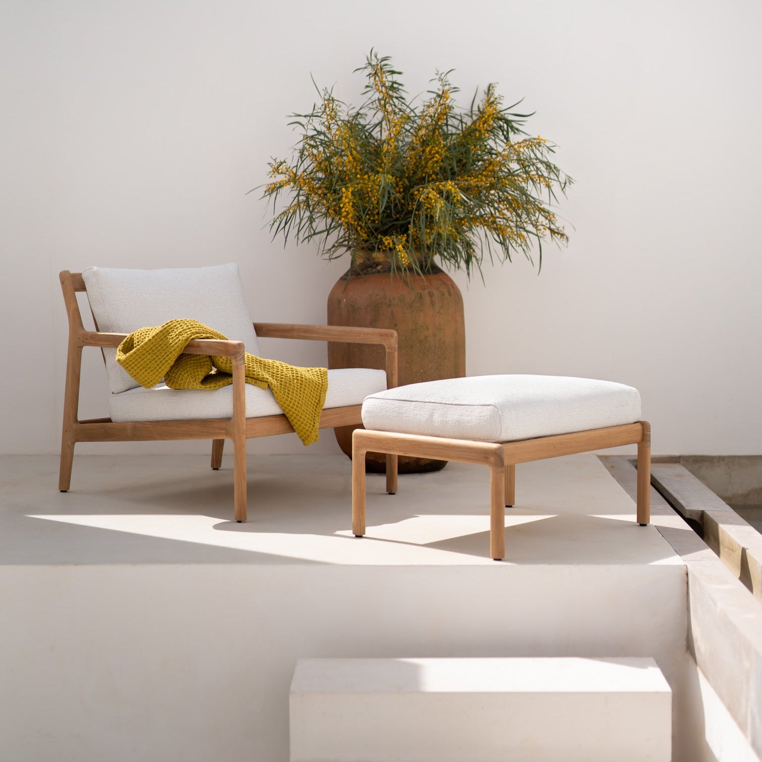 Loungestol Jack Outdoor Lounge Chair og puff Jack Outdoor Footstool fra Ethnicraft med pute i Off White.