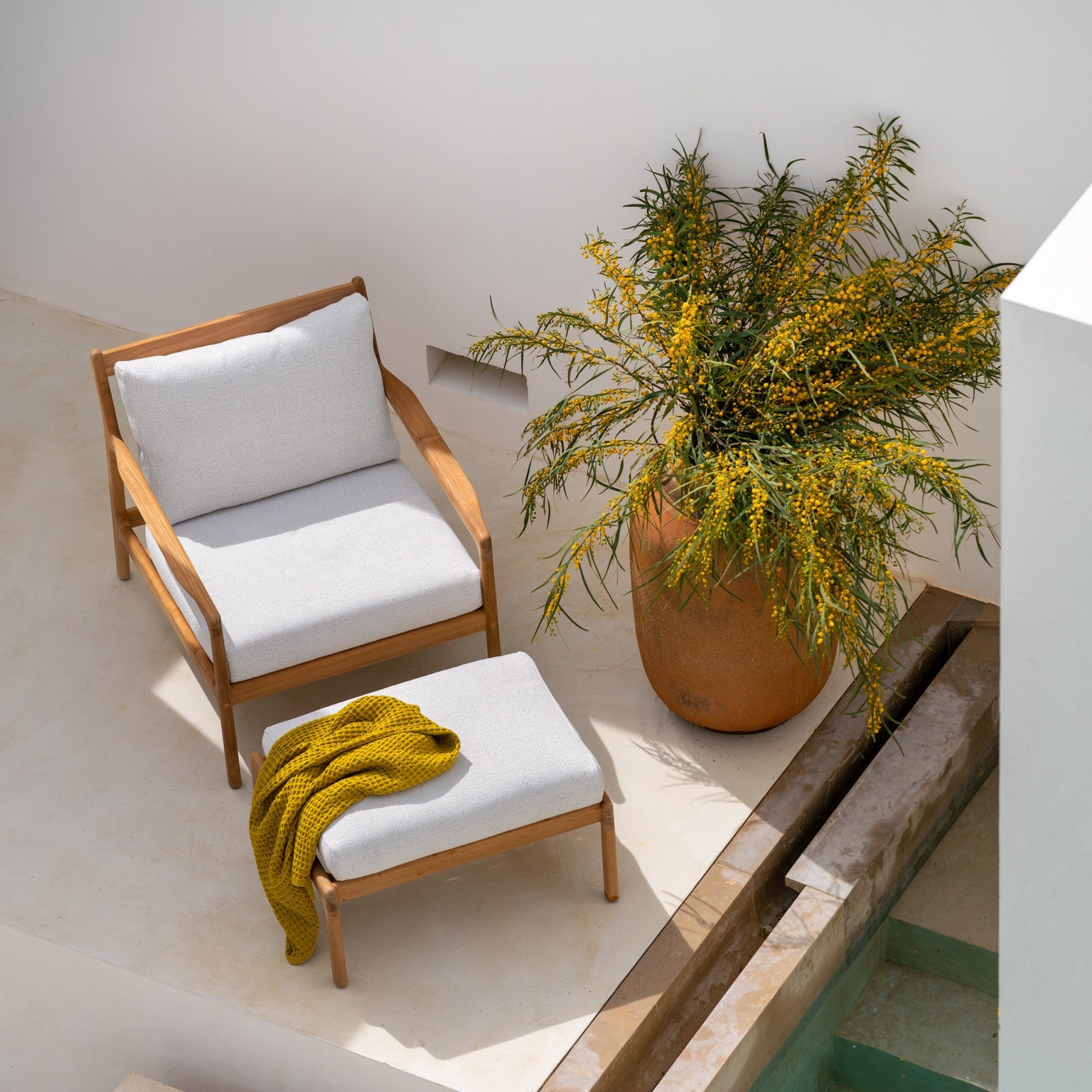 I likhet med de andre utemøblene i serien kjennetegnes loungestolen Jack Outdoor Lounge Chair og puff Jack Outdoor Footstool fra Ethnicraft av rene linjer, myket opp av avrundede detaljer. 