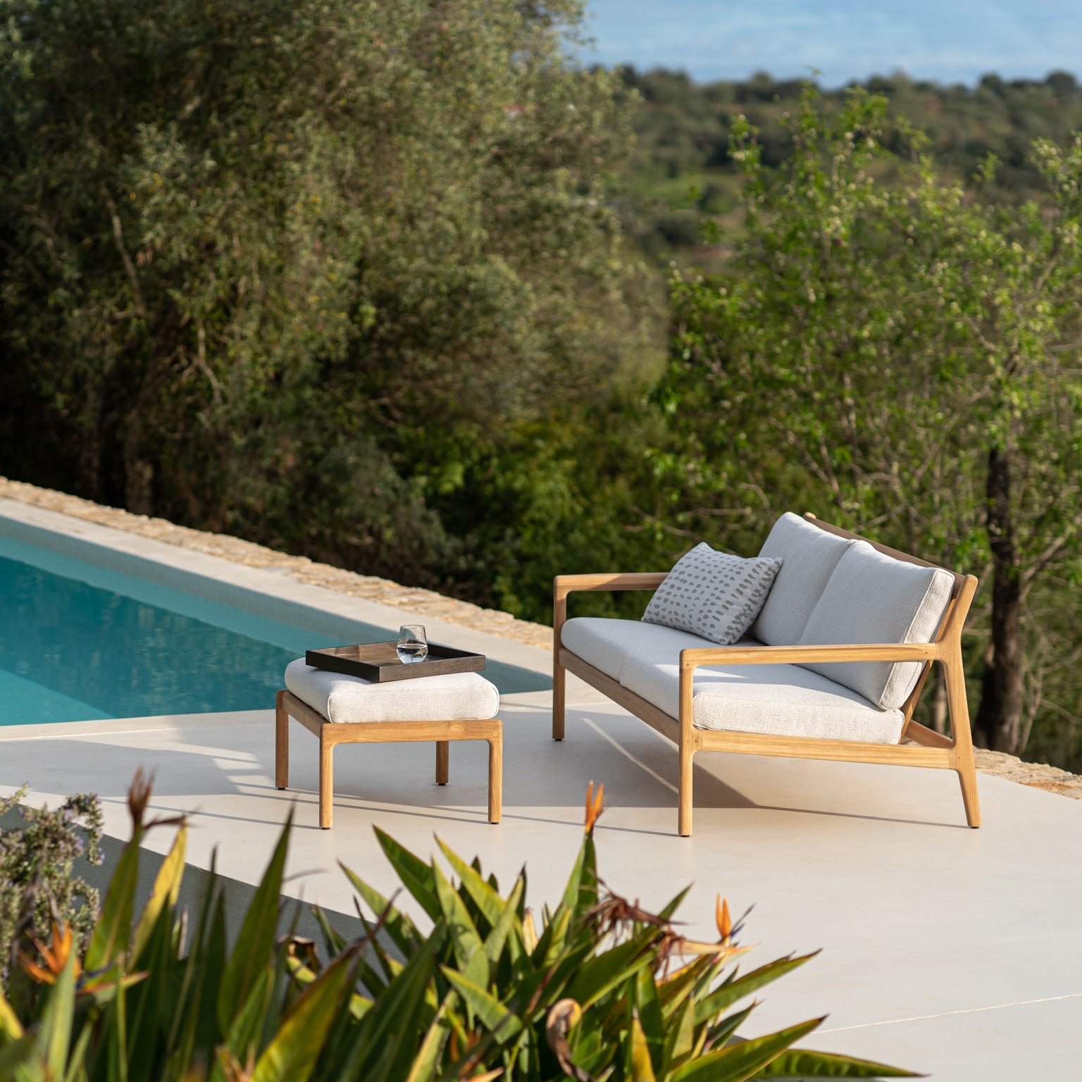 Sofa Jack Outdoor Sofa 2-seter og puff Jack Outdoor Footstool fra Ethnicraft med puter i Off White.