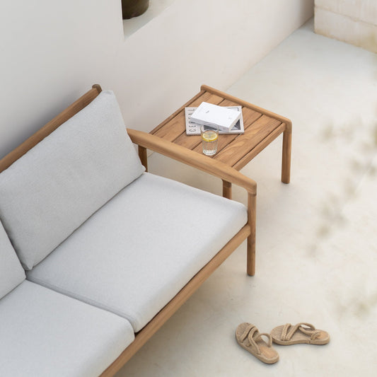 Den solide teakrammen til sofaen Jack Outdoor Sofa 2-seter og sidebordet Jack Outdoor Side Table fra Ethnicraft eldes vakkert over tid og gir et tidløst, naturlig preg til uterommet.