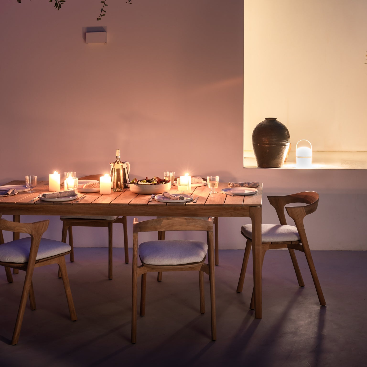 Spisebordet Bok Outdoor Dining Table og spisestoler Bok Outdoor Dining Chair med puter i off white fra Ethnicraft.