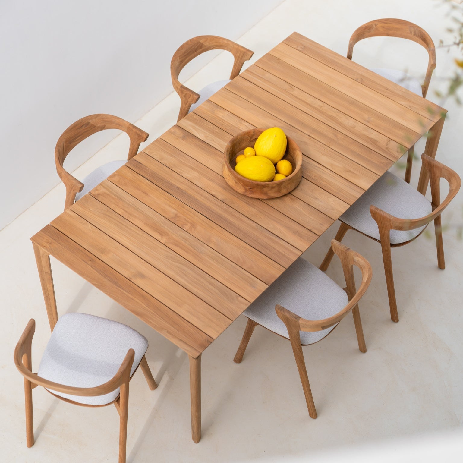 Spisebordet Bok Outdoor Dining Table og spisestoler Bok Outdoor Dining Chair med puter i off white fra Ethnicraft.