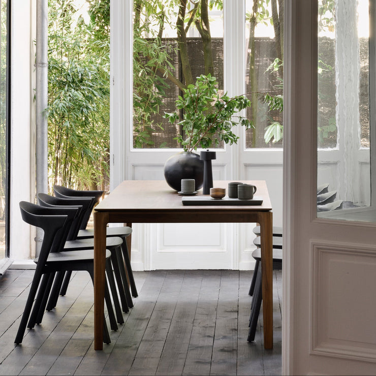 Spisebord Bok Dining Table fra Ethnicraft i brunlakkert teak. Det tidløse uttrykket gjør at det fint kan passe inn i moderne hjem såvel som i mer rustikke og klassiske innredninger.