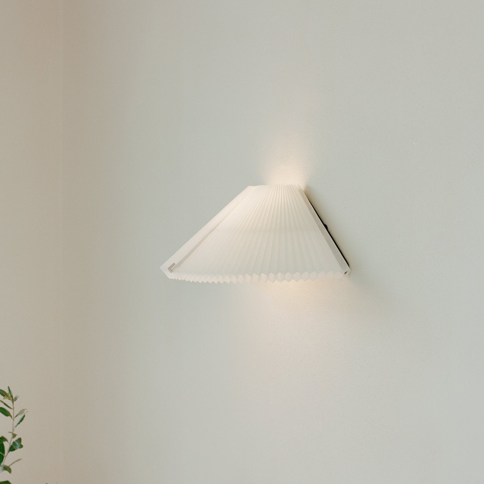 Vegglampen Nebra Wall Lamp fra New Works kombinerer klassisk design med funksjonalitet på poetisk vis: Den plisserte lampeskjermen er justerbar for å kunne tilpasses etter varierende lysbehov året gjennom og hvilken stemning man ønsker å skape i rommet.