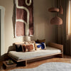 Sidebord Kona fra Ferm Living har et japansk-inspirert design, og er hevet over bakken til perfekt høyde.