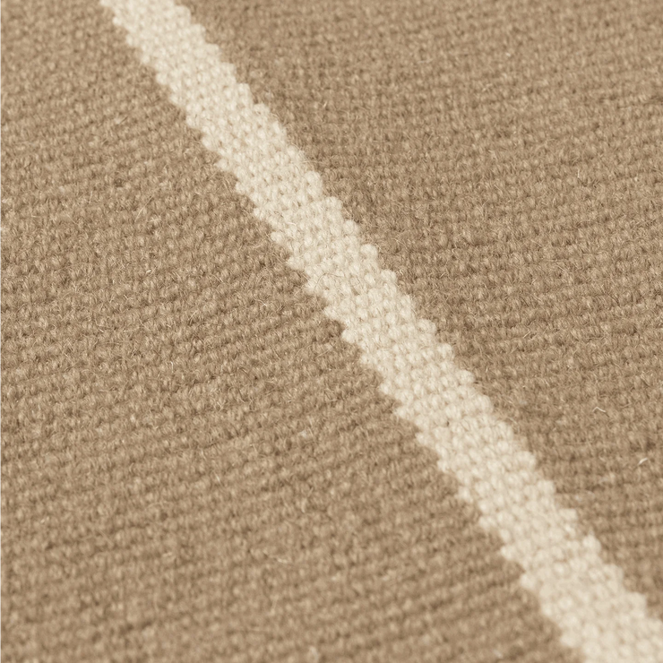 Det er håndlagde av 100% ull som er farget for hånd, noe som gjør hvert teppe unikt. Teppet i fargen Off-White/Dark Sand.
