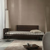 Dagseng Kona Bed i eikefiner, fra Ferm Living, i mørkbeiset utgave med madrass i det stripete tekstilet Pasadena.