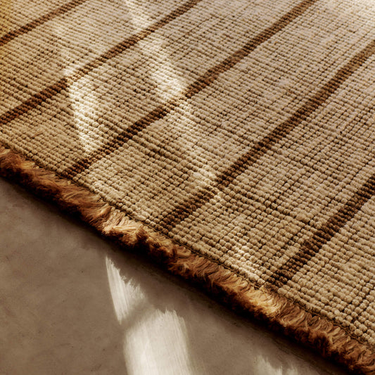 Teppe Athens Stripes Rug fra Ferm Living har tykke, myke frynser som understreker teppets mykhet og avslappede uttrykk.