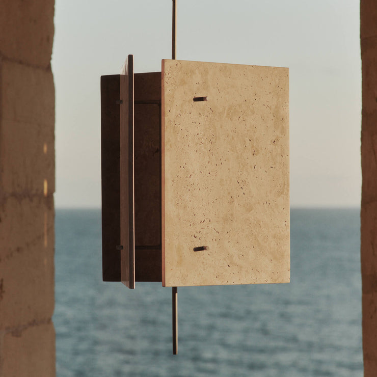 Det stramme designet til Pendellampen Oeste Pendant Lamp fra Ferm Living står i fin kontrast til travertinens naturlige, uregelmessige tekstur, og den varme, sandfargede kalksteinen lar seg lett kombinere med andre materialer og farger i interiøret.