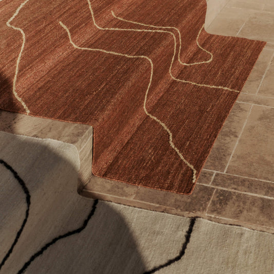 De abstrakte ullstripene i Teppe Gesso Jute Rug fra Ferm Living skaper et dynamisk spill som tilfører det lille ekstra i rommet uten å ta for mye plass visuelt. 