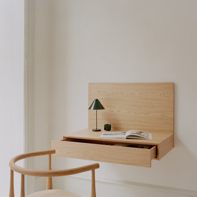 Med skjult oppheng og håndtak og rene flater i vakkert treverk er dette et diskré vegghengt skrivebord med skuff som kan passe fint inn på et mindre hjemmekontor, på et soverom eller i stuen. 