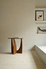 Sidebordet Geometric Side Table fra Ethnicraft er et vakkert og skulpturelt sidebord i heltre med mykt avrundede kanter og et formmessig spennende understell. Buede former og rette vinkler skaper lekne kontraster med lys og skygge og gjør sidebordet til et blikkfang fra alle vinkler.