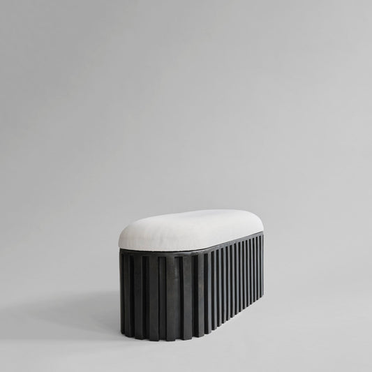 Benken Tribu fra 101 Copenhagen er inspirert av gamle stammeskulpturer og er laget av en betongbase med en elegant off-white pute i lin for ekstra komfort.