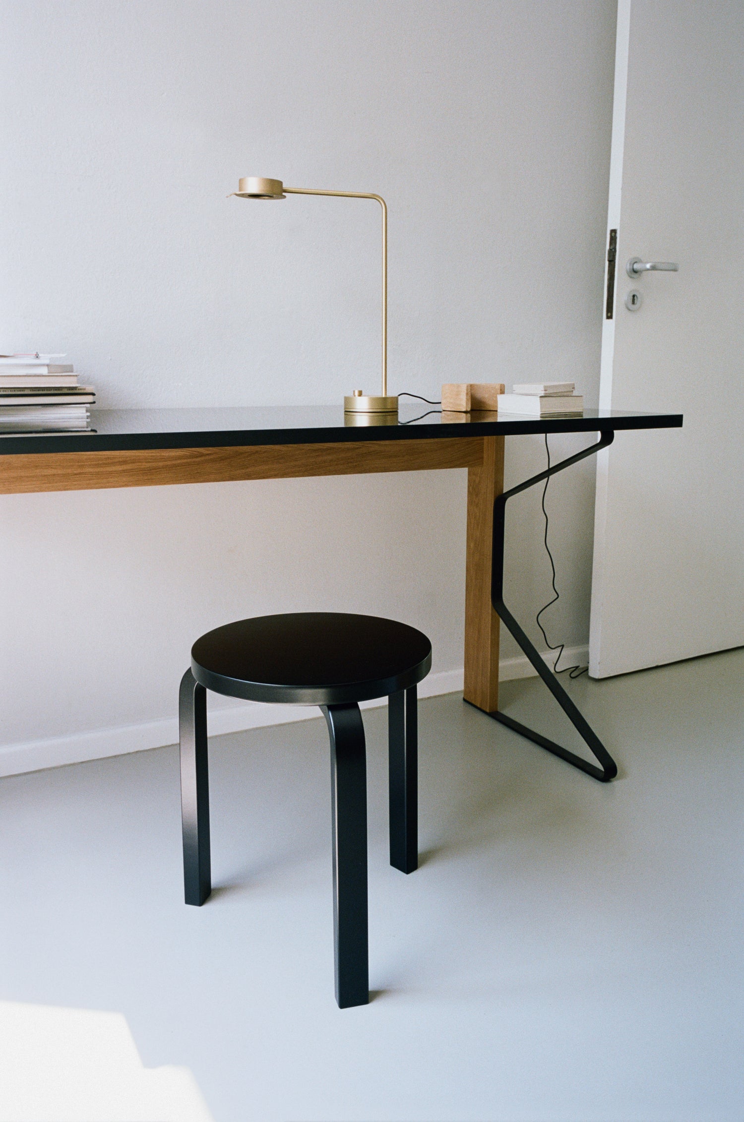 Bilde av skrivebordet Kaari Desk fra Artek på et hjemmekontor. Skrivebordet står sammen med den ikoniske krakken Stool60 fra Artek.