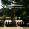 Den mørkebrun- og hvitstripete parasollen Patio Umbrella Stracciatella fra HK Living med bølget kant er som hentet ut av et av Slim Aarons ikoniske fotografier fra 70-tallet – perfekt for deg som ønsker litt ekstra skygge med stil.