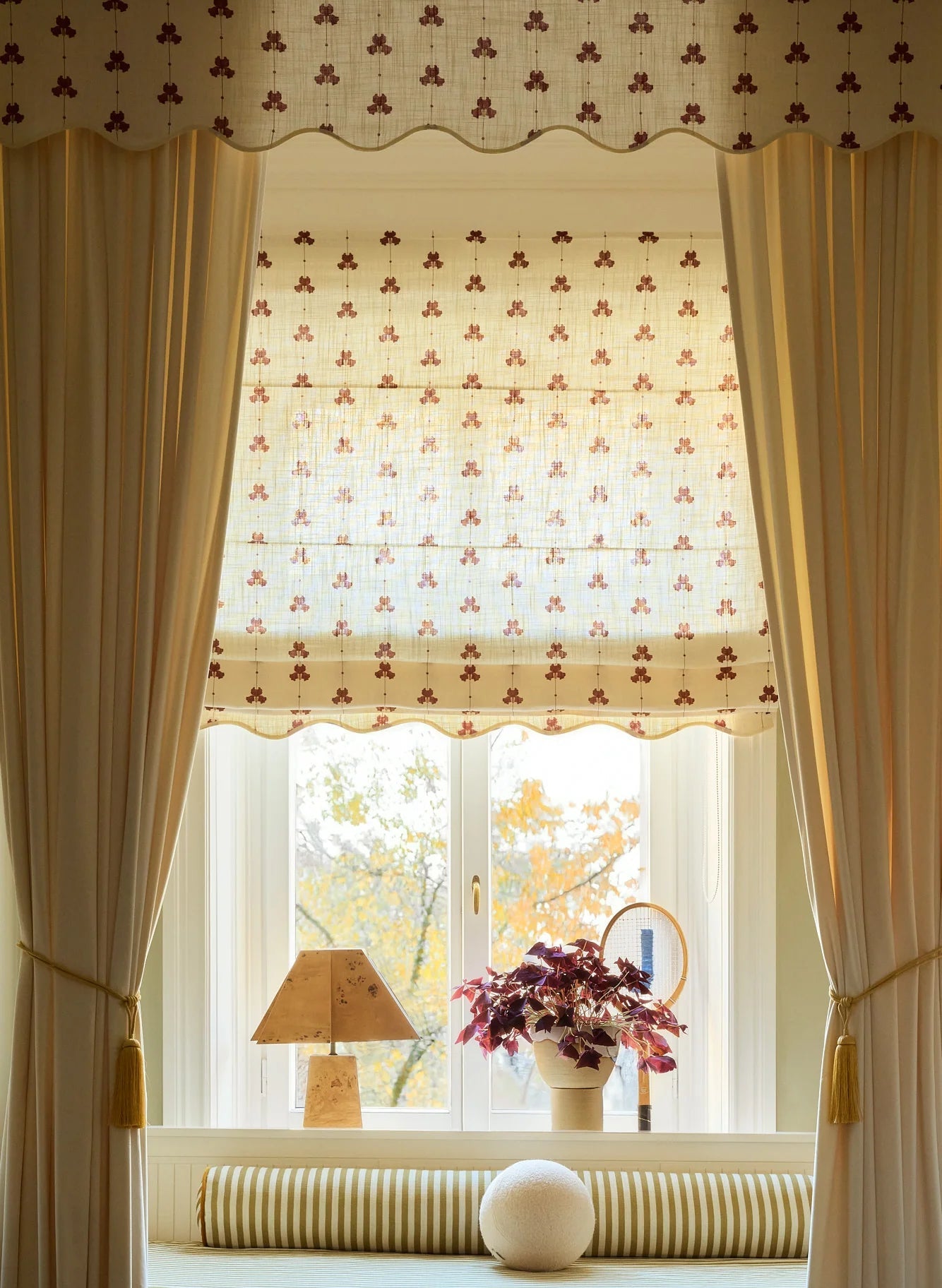 Liftgardin Scallop Edge Sweet Pea fra Gotain – har et vakkert erteblomstmønster og bølget kant. Perfekt for deg som ønsker deg en elegant og hakket mer dekorativ liftgardin. Her i fargen rød / Burgundy