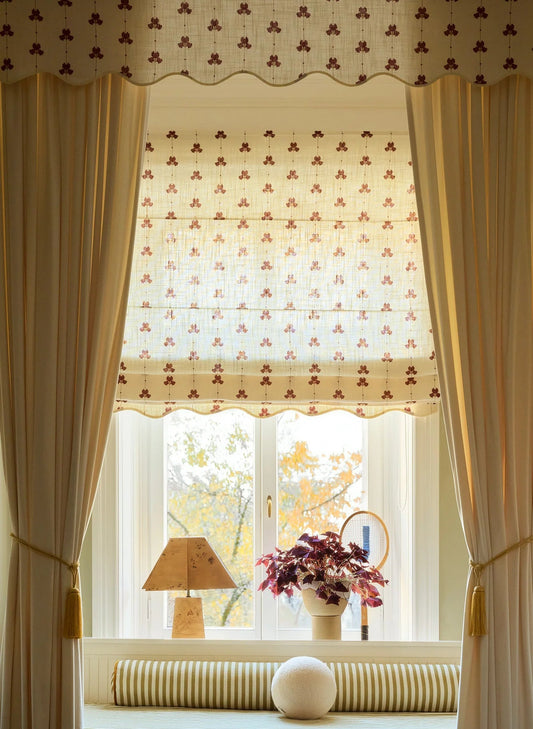 Liftgardin Scallop Edge Sweet Pea fra Gotain – har et vakkert erteblomstmønster og bølget kant. Perfekt for deg som ønsker deg en elegant og hakket mer dekorativ liftgardin. Her i fargen rød / Burgundy