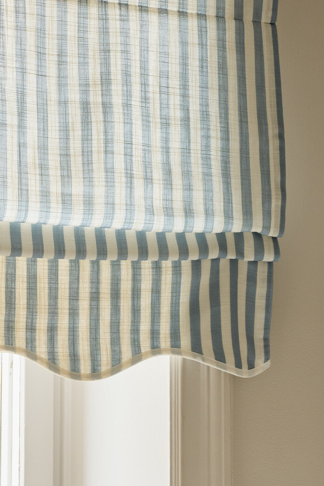 Stripete skreddersydde liftgardiner i vevd lin levert hjem - enkelt og greit. Denne varianten – kalt Scallop Edge fra Gotain – har en vakkert bølget kant og er perfekt for deg som ønsker deg en elegant og hakket mer dekorativ liftgardin. Her med blå striper i fargen Dove Blue.