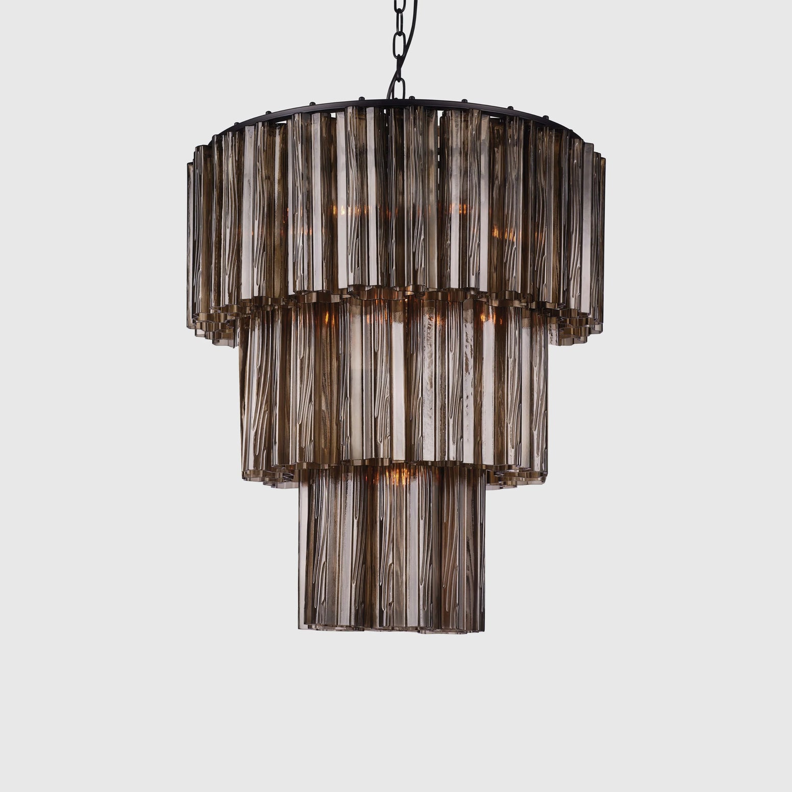 Lysekronen Fontaine Chandelier fra norske Meublé smykker ethvert rom den henger i! Vakkert formede glassylinderne i munnblåst brunt glass slipper lyset gjennom på en delikat måte og gir rommet en helt egen stemning når den er tent. Her i den mellomste størrelsen, med 3 lag. 